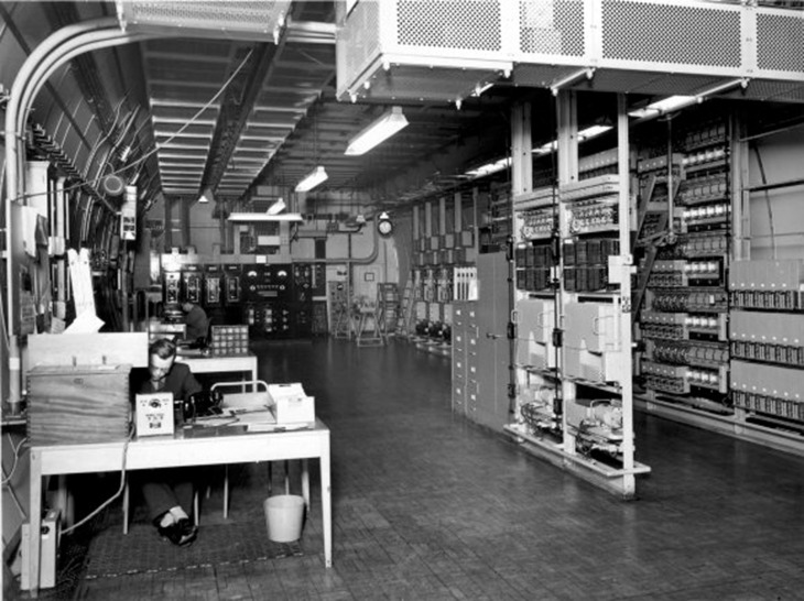 People working at desks in an underground control centre