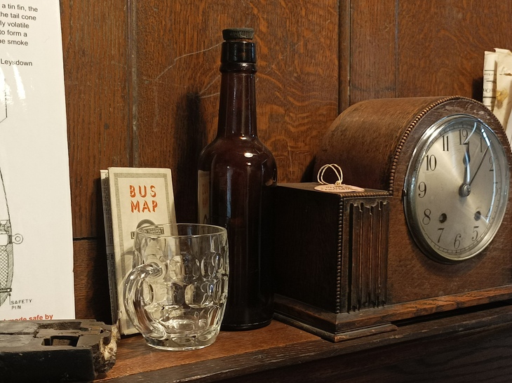 Close up of the mantlepiece, with clock, bus map and beer jug