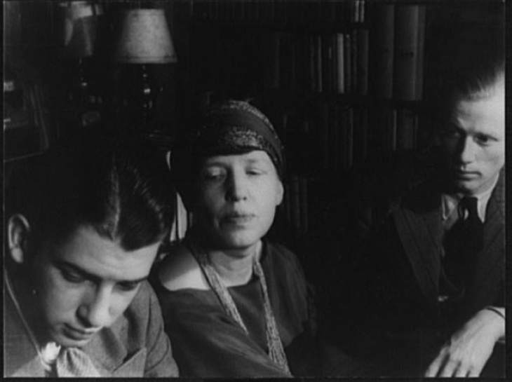 Black and white image of two young men sitting either side of their mum