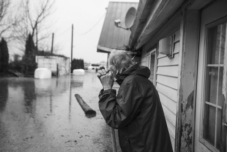 A man looking at his flooded neighborhood. 