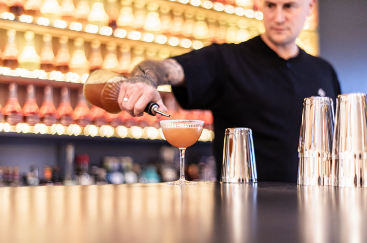 A barman pouring a cocktail