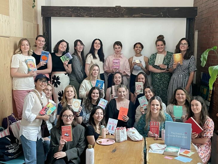 Women from The Lonely Girls Club holding the books they have acquired at the book swap 