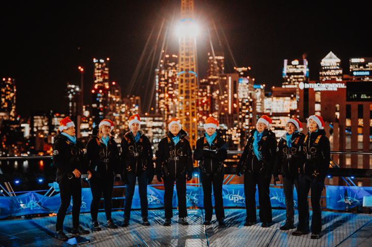 Carollers in Santa hat on top of the O2