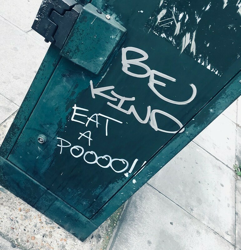 A bit of graffiti says "Be kind Eat a pooo!
