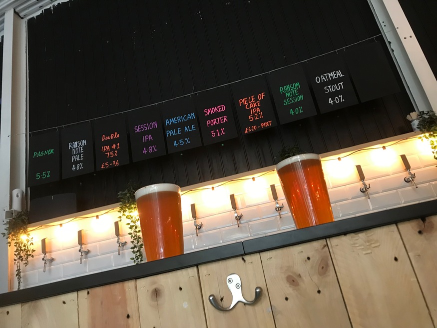 Best Restaurants, Bars, Cafes And Pubs In Forest Gate: Two pints of beer on a bar, with chalked up beer menu behind it