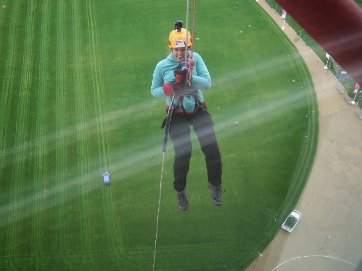 A woman dangling by a rope in mid air