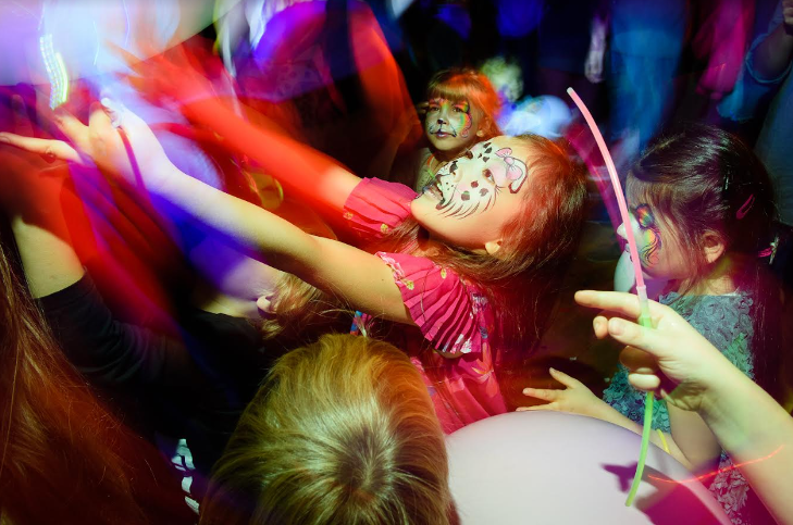 Children with painted faces on the dancefloor