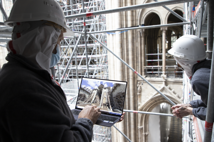 Work people studying the cathedral from scaffolding