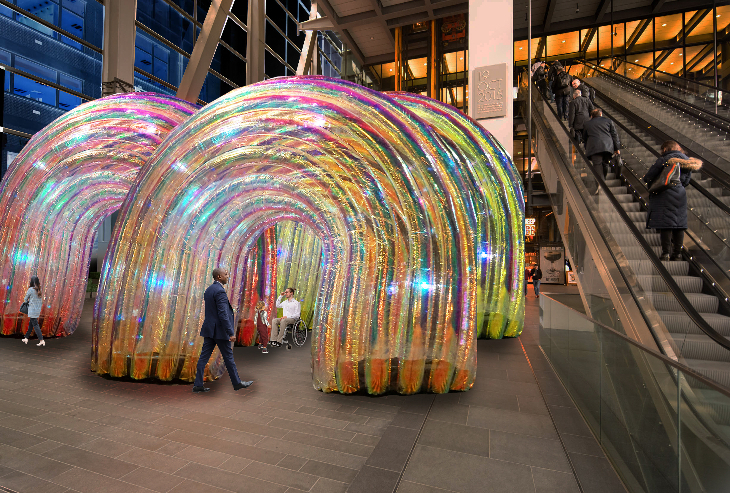People walking among giant plastic rainbows, outside the entrance to the Cheesegrater building