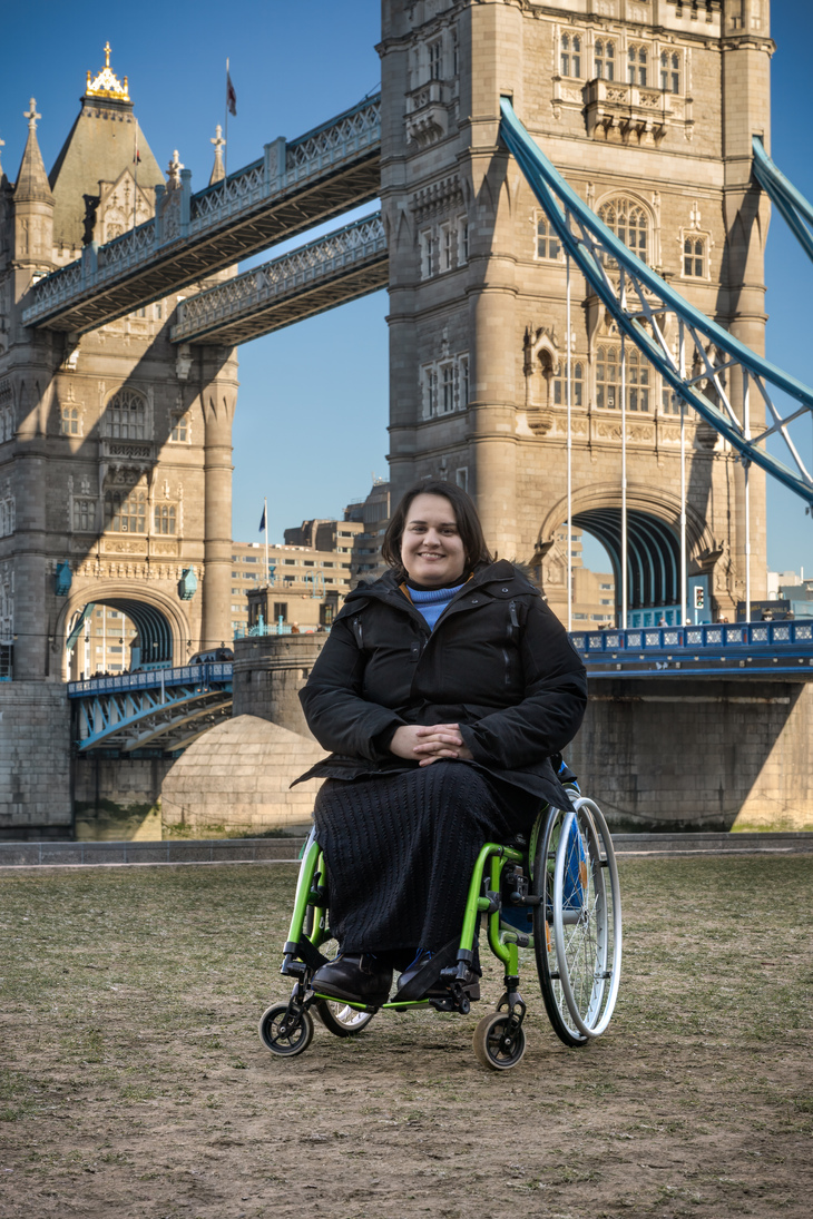 A woman in a wheelchair in front of Tower Bridge