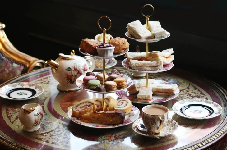 Best budget afternoon tea London: A table with two tiered afternoon tea stands, plus a teapot and crockery