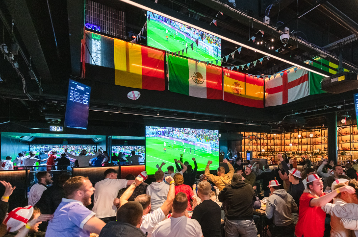 People celebrating in front of a large screen