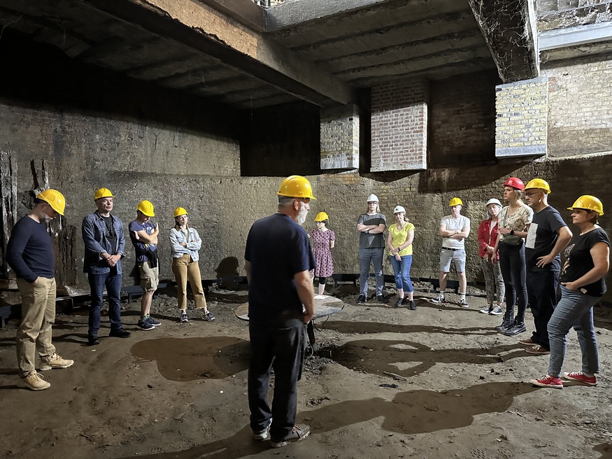 People in hard hats standing in one of the wells