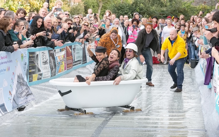 People sliding on ice in a bath tube