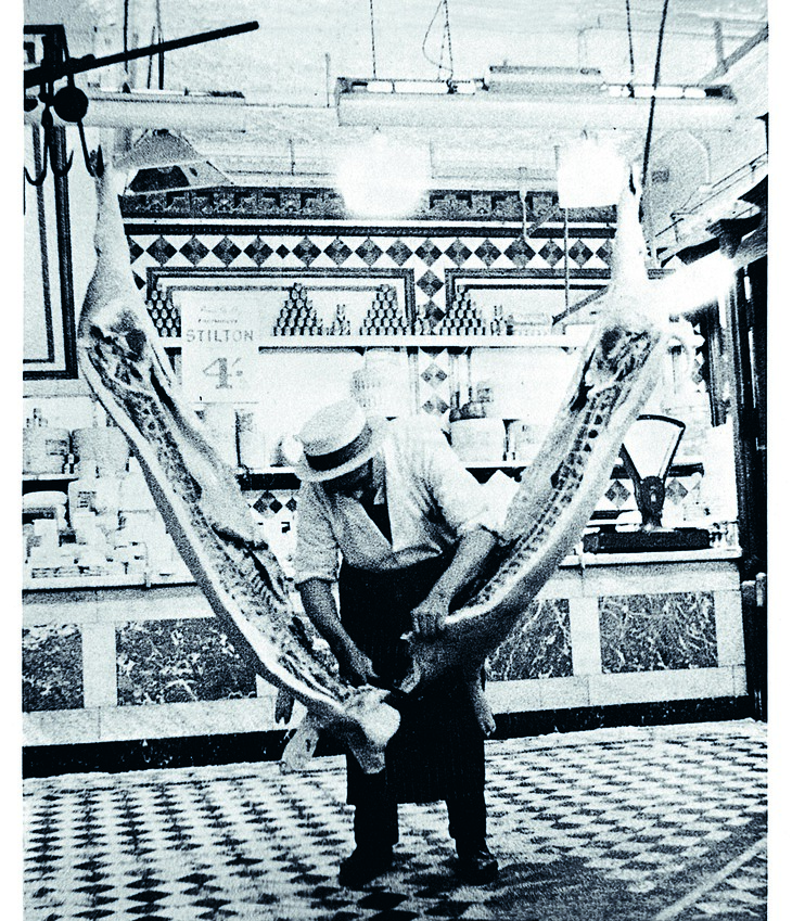 A butcher slicing a carcass