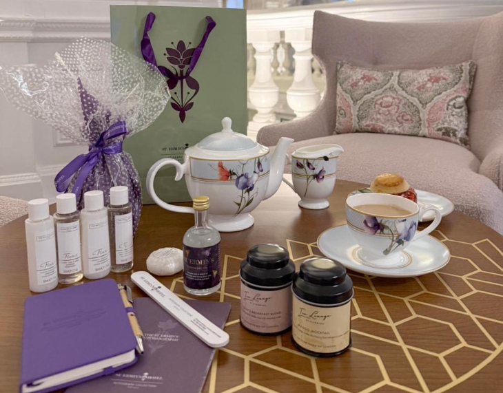 A tea set on a table alongside gifts including toiletries