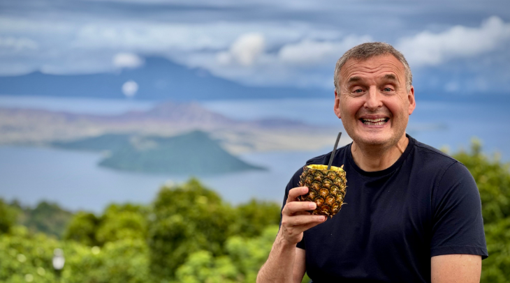 Phil Rosenthal holding a pineapple and smiling for the camera