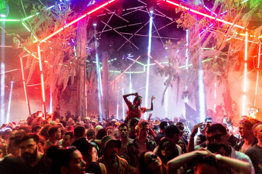 People at a festival, illuminated with colourful lights
