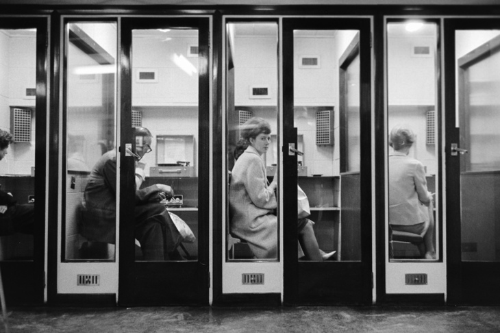 People sitting in record listening booths