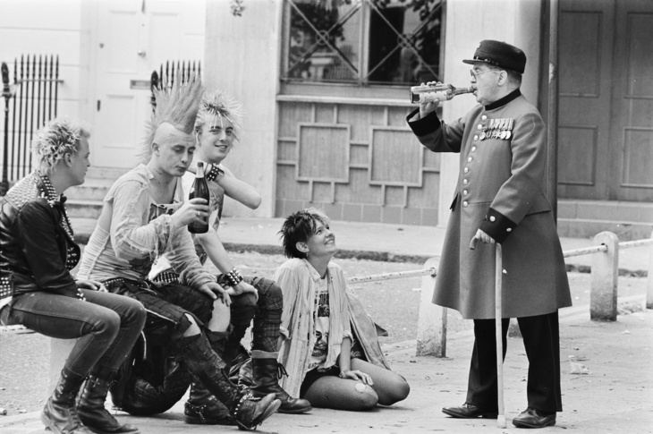 A Chelsea Pensioner drinking with a group of punks
