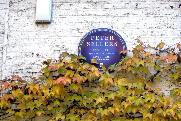 A plaque to Peter Sellers, partially covered by leaves