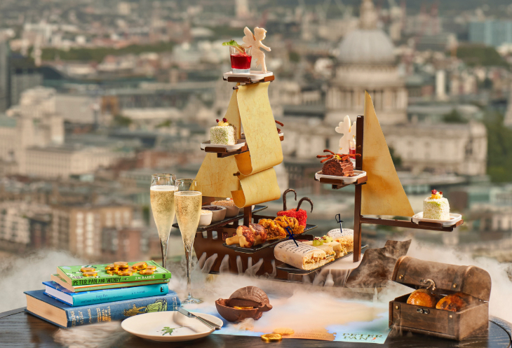Bookish afternoon tea London: afternoon tea served on a stand shaped like a pirate ship, with views over London through the windows behind