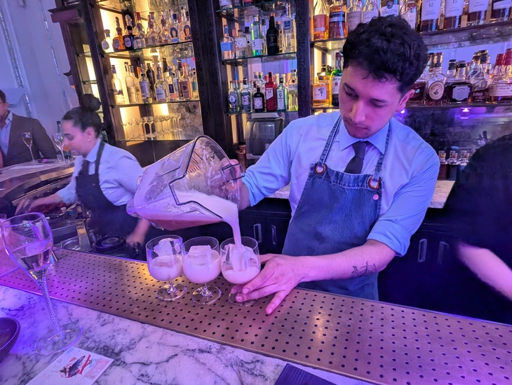 A bartending pouring drinks