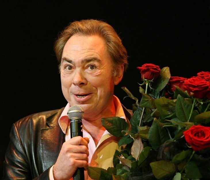Andrew Lloyd Webber clutching some roses, as though he's about to sing