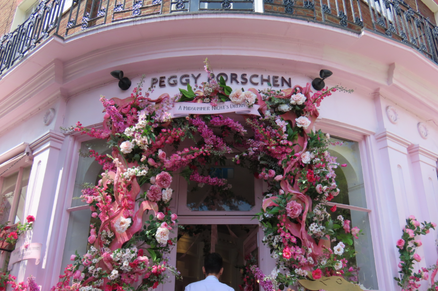A pink floral arch around the entrance to pink cafe Peggy Porschen