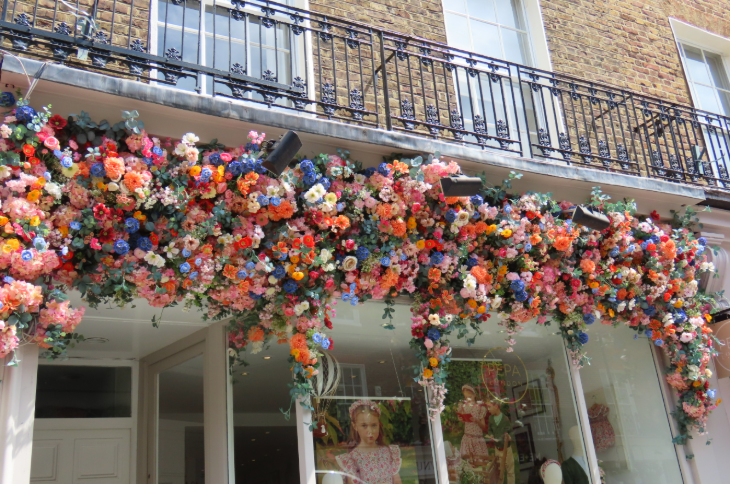 A multicoloured floral decoration above a shop window