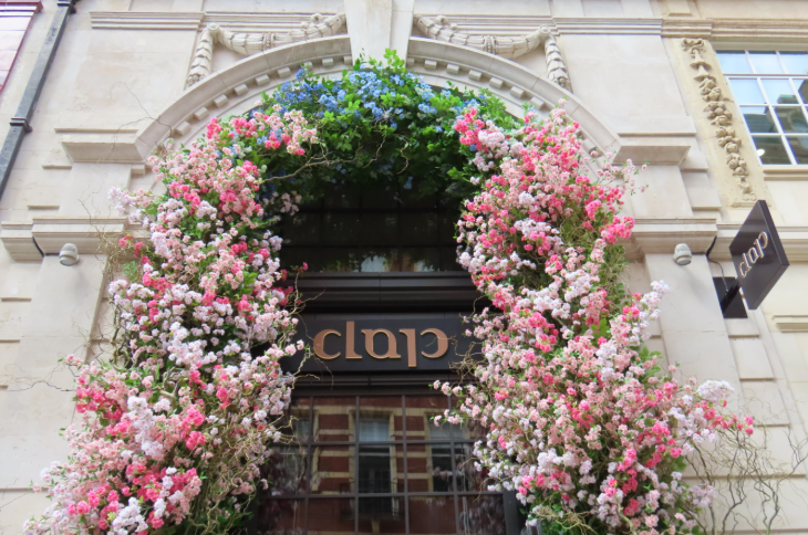Pink and blue flowers in an arch around a restaurant door