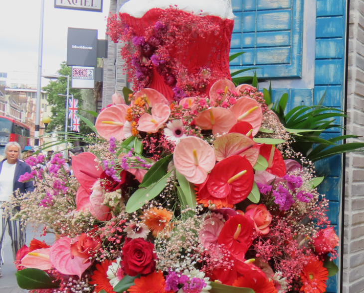 A dress made from a red corset, with a large skirt made from pink and red flowers