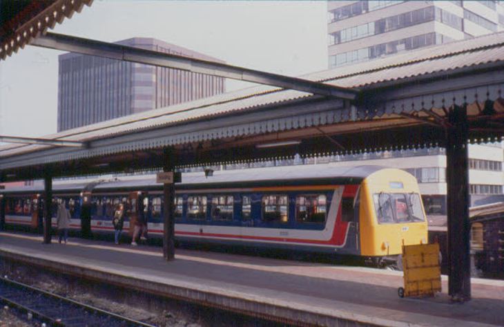 A photograph of a blue, white and red Network SouthEast train alongside a platform at Reading station
