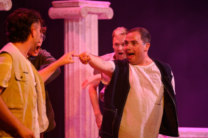 Actors on stage in front of a Roman-style column in Pop Off, Michelangelo!