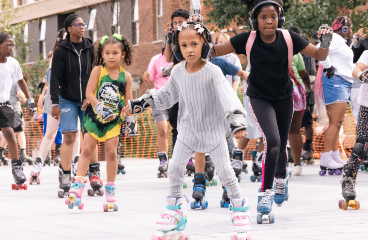 People wearing headphones and roller skating