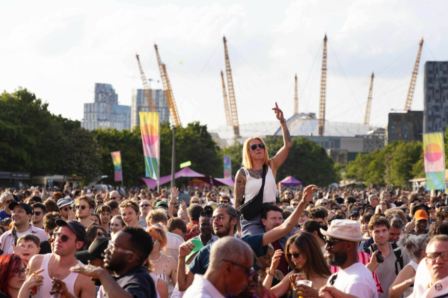 A crowd at an open-air festival, with the O2 dome visible in the background
