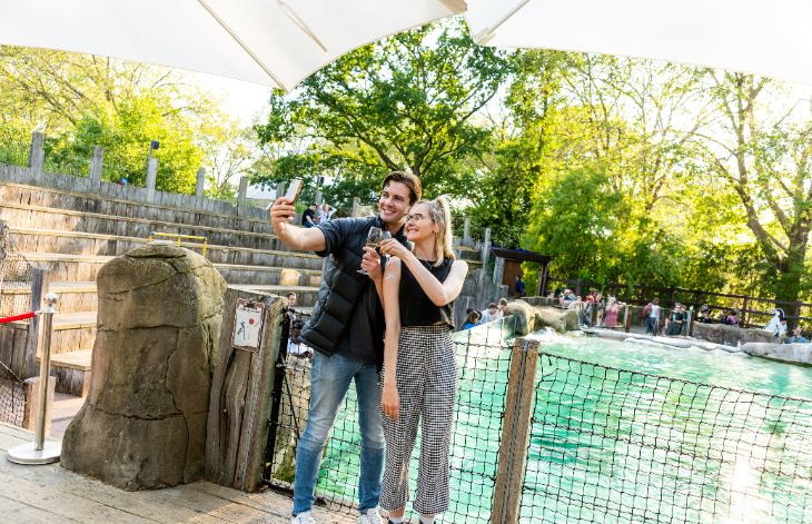 A couple taking a selfie by the penguin pool at London Zoo