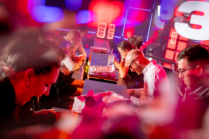 People playing bingo in a fluorescent pink setting