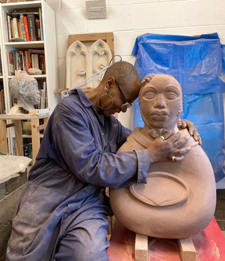 The artist embracing her statue