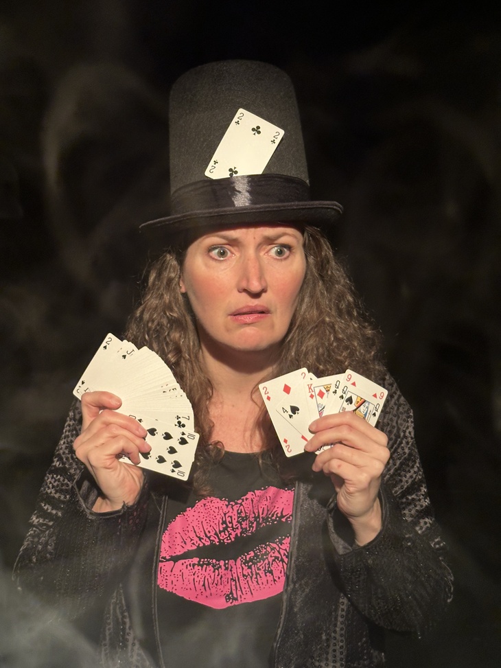 A person with a big hat and lots of playing cards