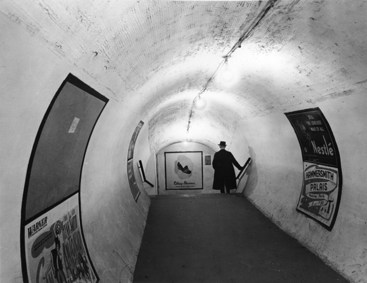 A person disappearing down stairs in a passageway