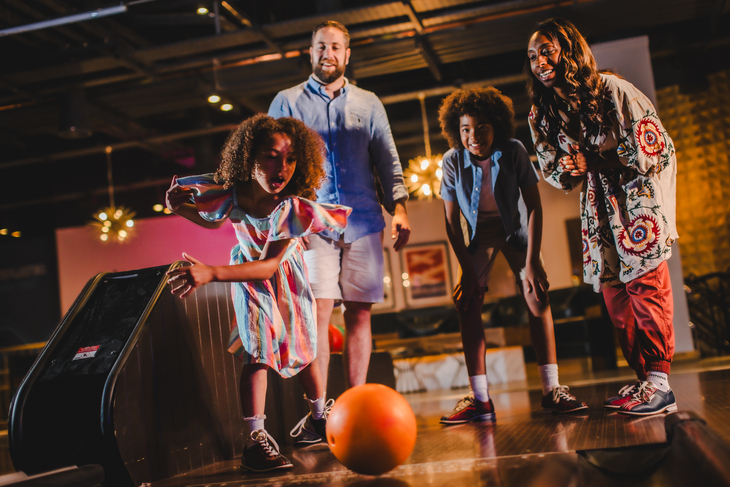 Parents bowling with their kids