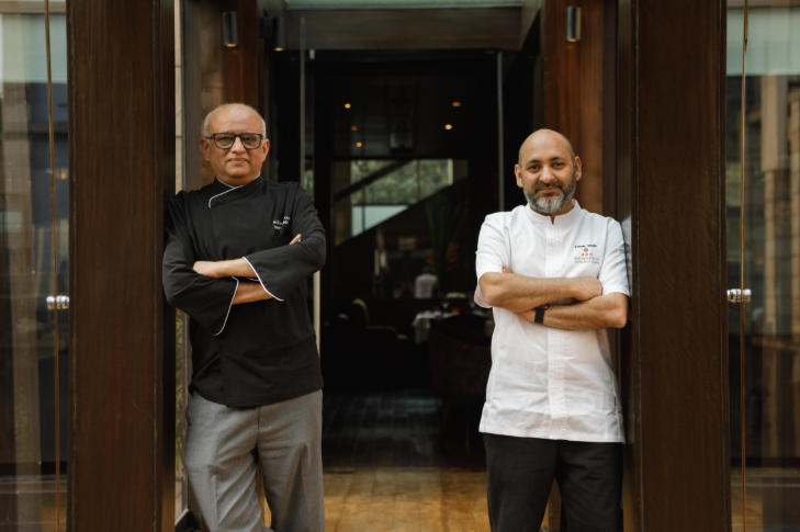 Chefs Sameer Taneja and Shantanu Mehrotra  posing in front of a restaurant door