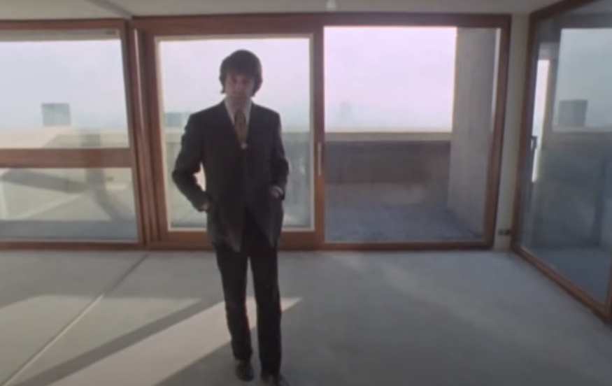 A man in a suit in an empty apartment