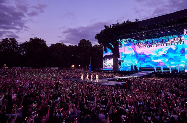 A festival crowd watching performers on a stage
