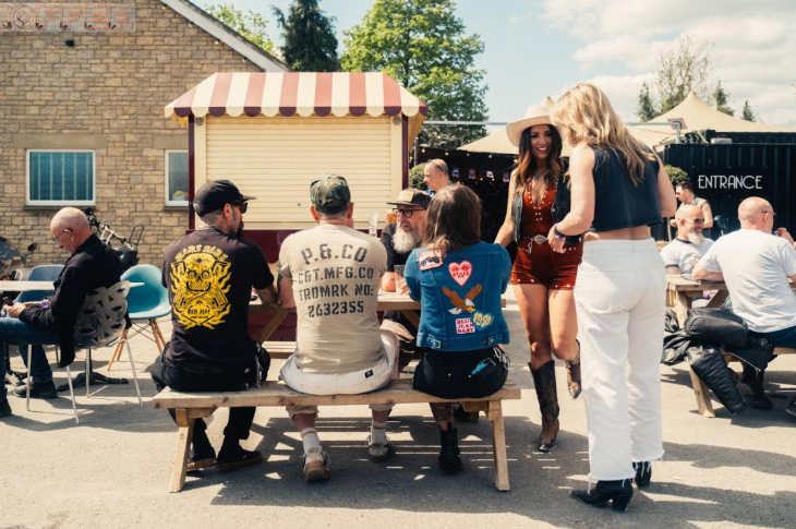 People sitting and standing around picnic benches at a previous Connected Plates event