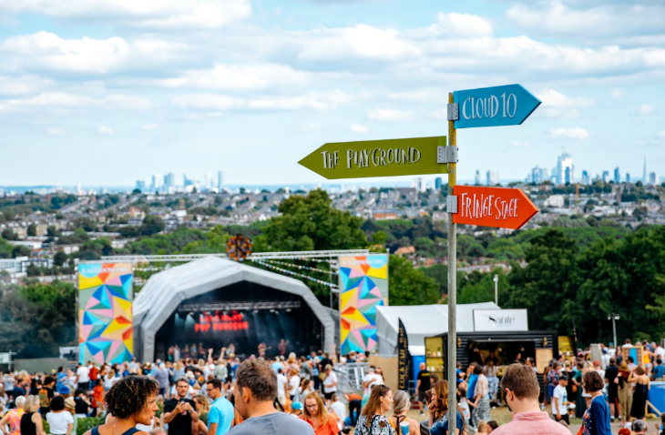 A festival with music stage in the grounds of Ally Pally, with the London skyline in the background