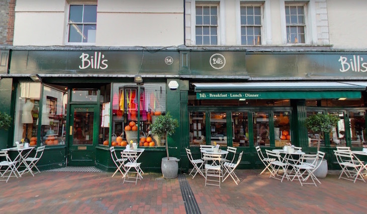 Where to eat in Lewes: the dark green exterior of Bill's with tables and chairs on the pavement outside