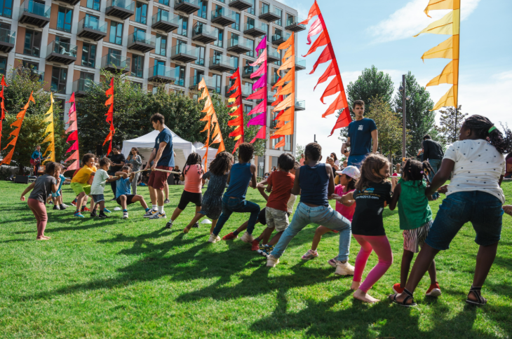Children taking part in a tug of war in a park