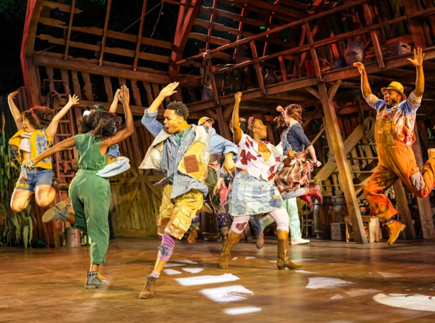 Cast members on stage dancing in Shucked